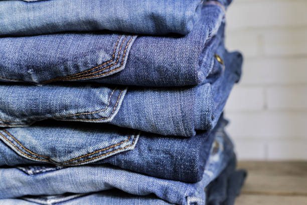 Stack of blue jeans on wooden shelf. Beauty and fashion clothing concept