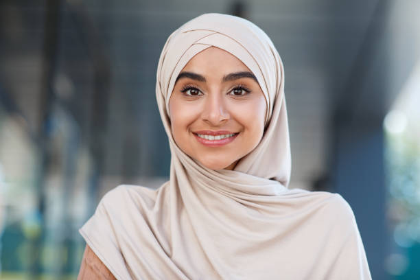 Head shot of beautiful woman student, teacher or blogger. Portrait of smiling millennial beautiful nice middle eastern woman in hijab look at webcam, make video call outdoor, close up, free space