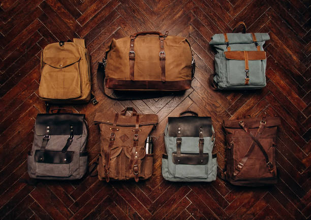 Many different travel bags on the floor. Canvas bagpacks and bags. Top view