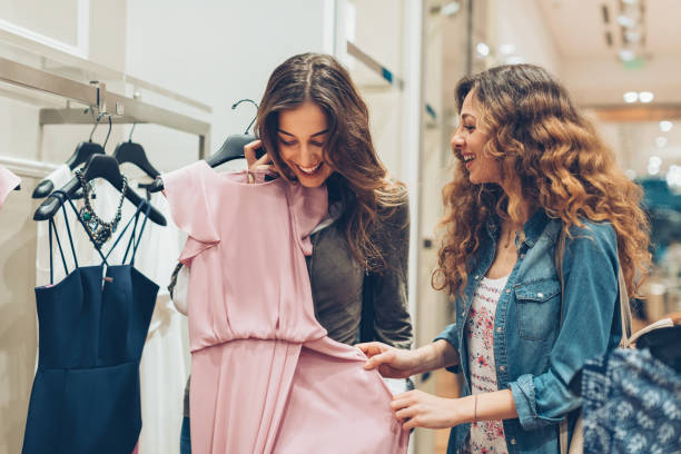 Two young women choosing dresses in a luxury fashion store